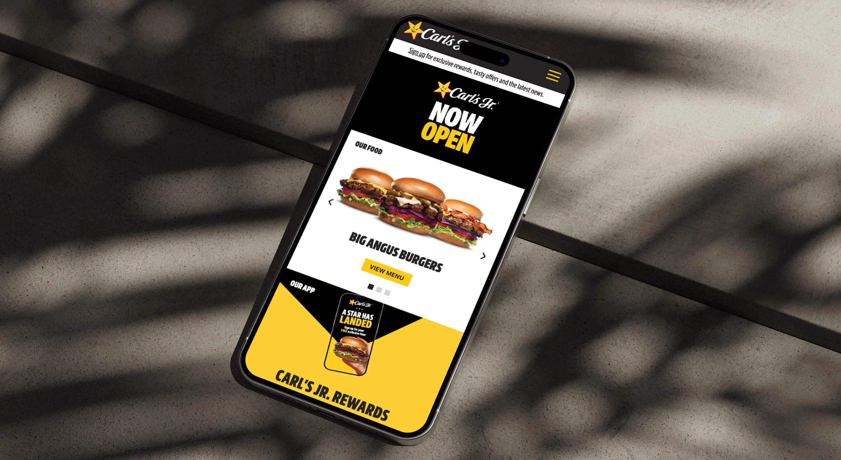 Carl's Jr home page on a phone lying on the ground