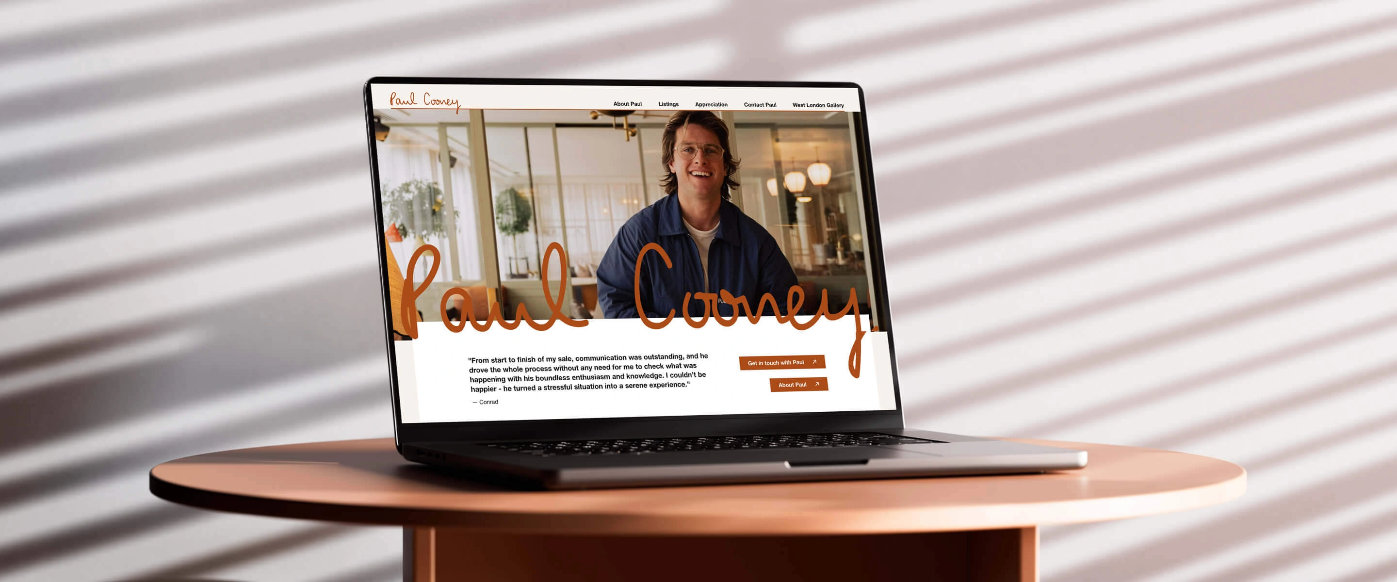 Paul Cooney's home page on a laptop screen on a table