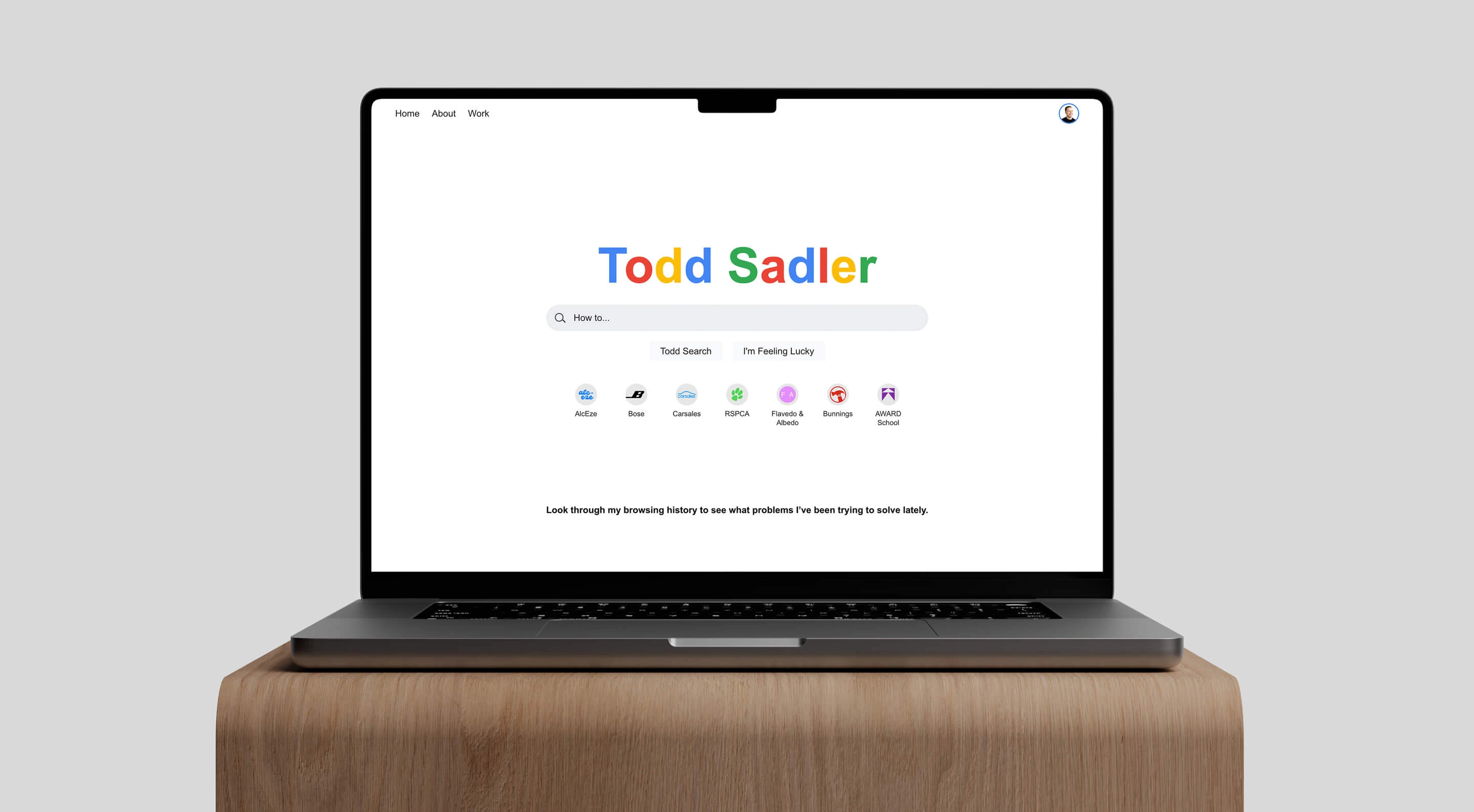 Todd Sadler's Google-inspired home page on a laptop screen placed on a wooden plynth