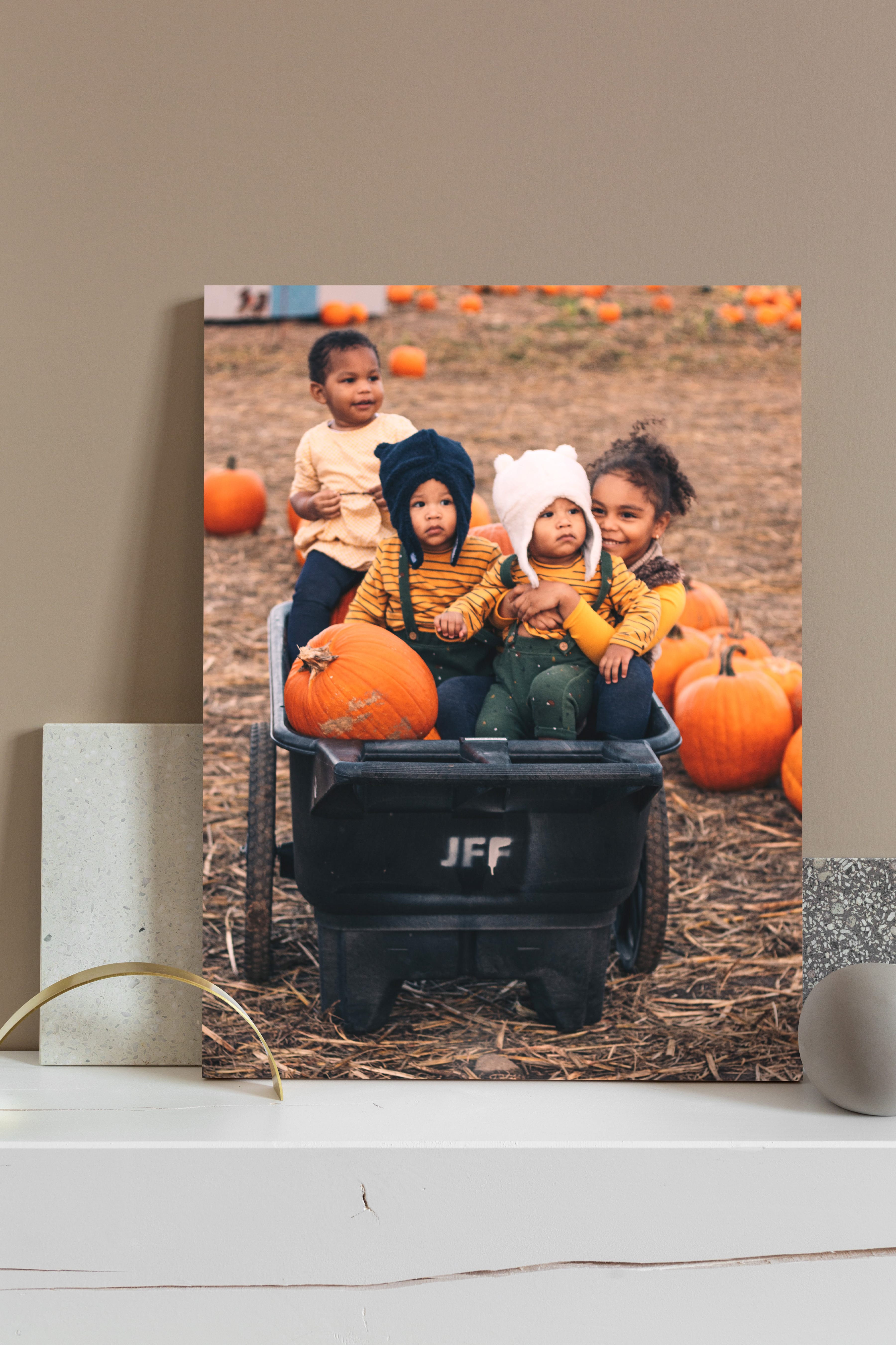 Canvas print on mantle of children at the pumpkin patch