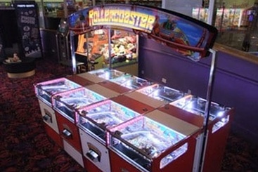 view of mutiple coin drop slot machines inside an amusement arcade that use accuride slides.