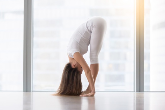 Woman doing intense Leg Stretch Pose D, Wide Legged Forward Fold