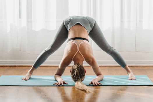 Slim woman doing Salamba Sarvangasana pose on yoga mat - a Royalty