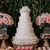 Massive layered white ornate lambeth wedding cake with edible flowers