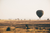 a hot air balloon going across the serengetian desert