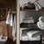 wooden bathroom storage filled with white towels 