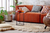 Brown sofa with textured rug and layered cushions