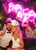 smiling newlyweds in front of neon signage decor