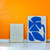 blue abstract paintings leaning against an orange wall 