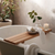wooden bath ledge with plant and candle on top of it 