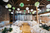 wedding tables with green and white lanterns in a barn