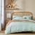 teal linen bedding with a wooden famed bed 
