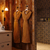 matching brown robes hung up in a mochocromatic bathroom 