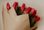 red tulip bouquet wrapped with brown paper 