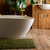 white bath tub in a wooden bathroom with green accents 