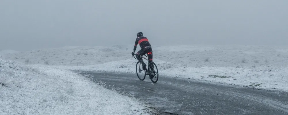 Road rider cycling in the snow