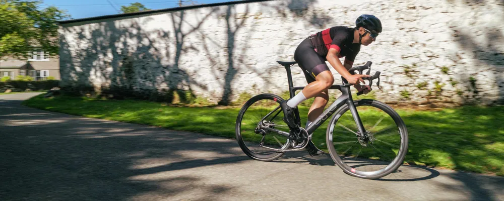 a road bike rides past a white wall