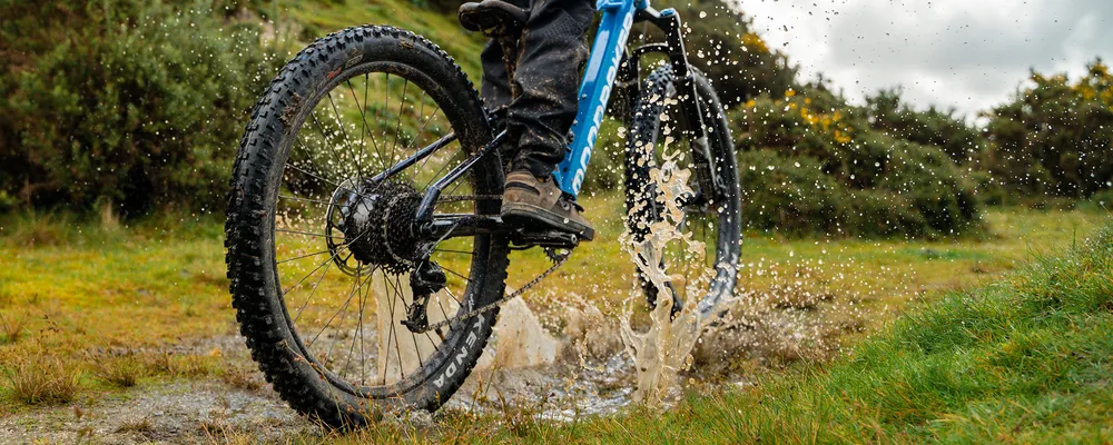 close up of 24 inch tyres splashing through a puddle