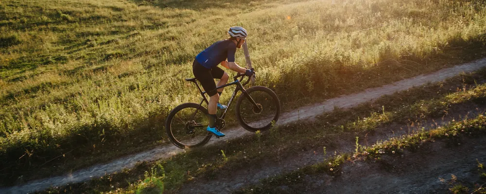 A cyclocross bike is ridden uphill at sunset