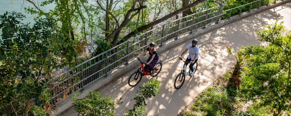 Hybrid bikes are ridden alongside a river