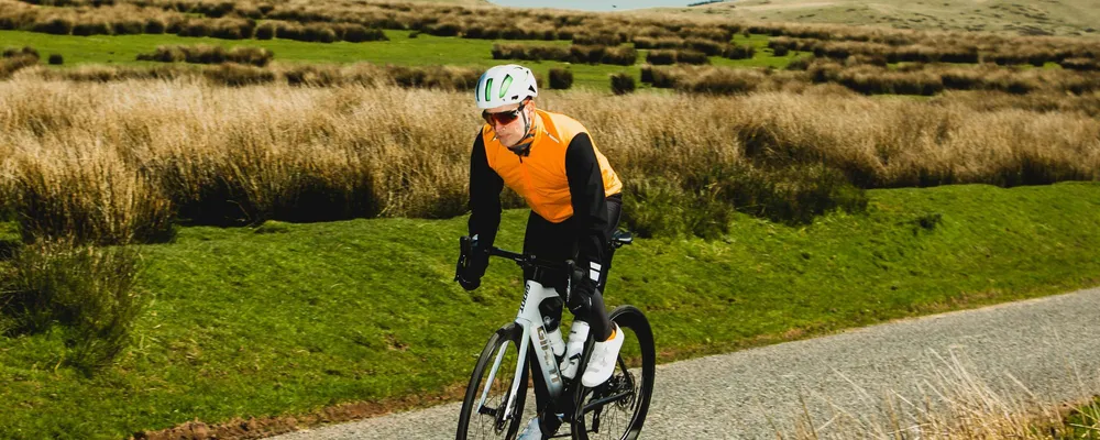 Road rider wearing orange vest