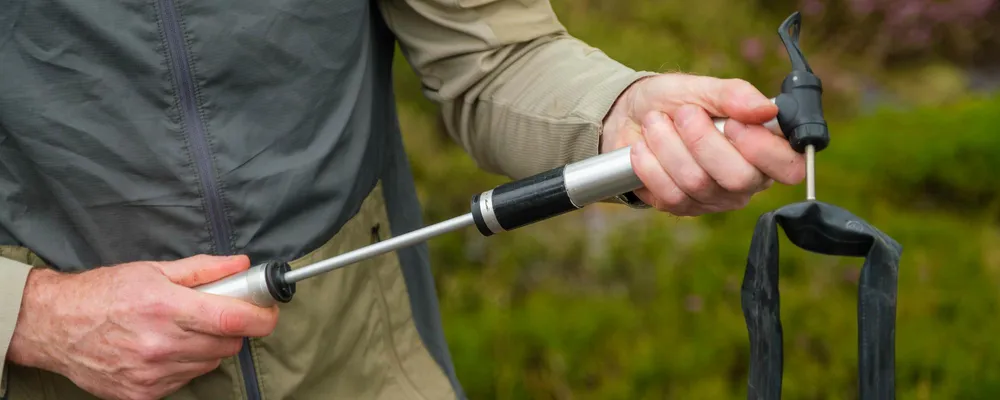 using a hand pump to pump up an inner tube on a bike