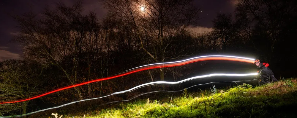 light trail mtb night riding in the woods under moon light