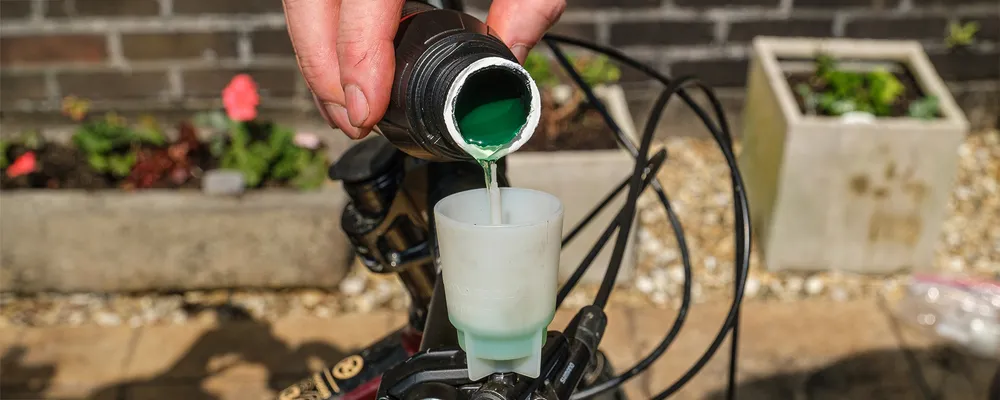 brake fluid pours into a bleed bucket