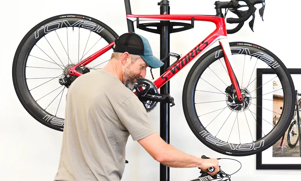 man hanging bike on storage bar