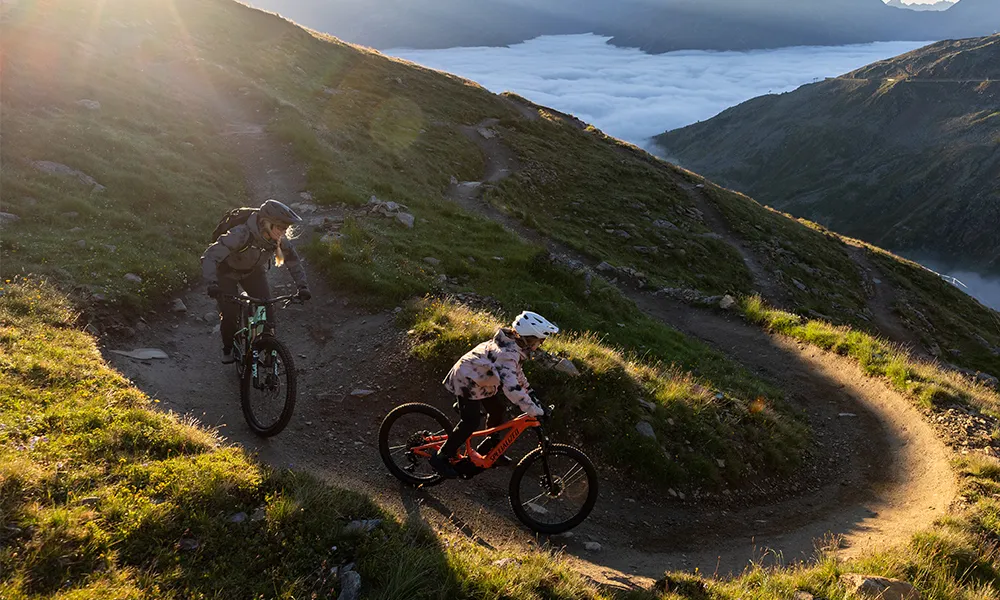 child and adult riding electric bikes on epic mountain terrain