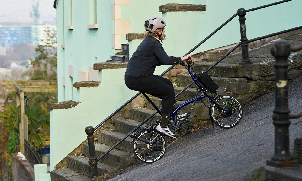 riding an electric folding bike up a steep hill