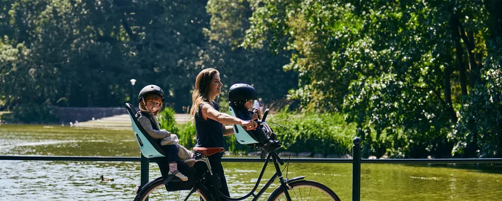 woman with two kids in bike seats on a bike