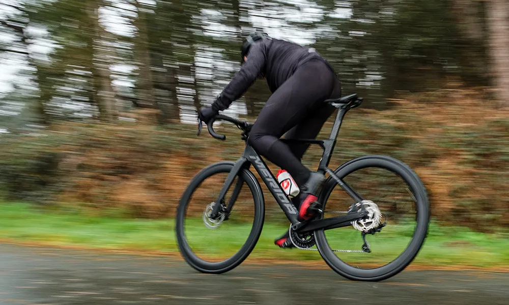 a black road bike rides past at speed