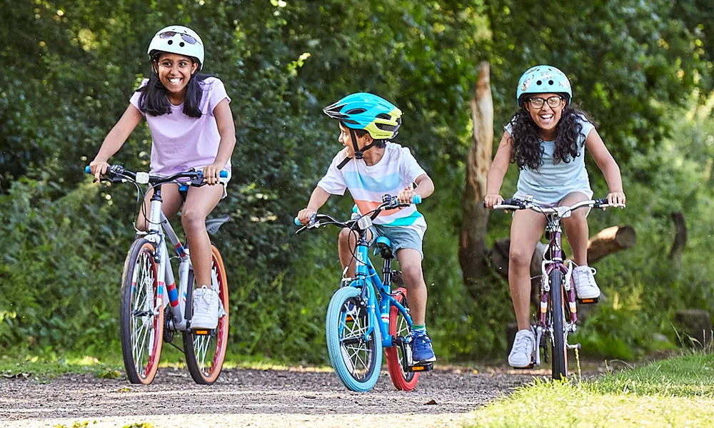 three kids riding bikes on a summer day