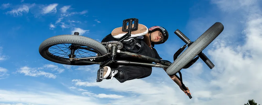 a bmx jumps through the air close up on the tyres