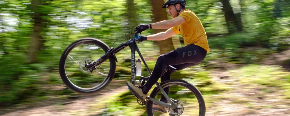 MTB rider manualing wearing cycling trousers on a marin bike