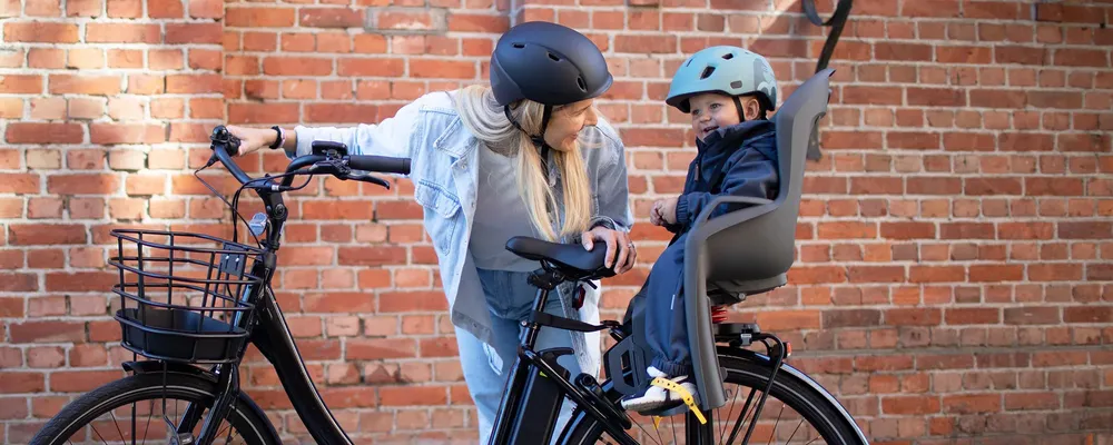 woman talking to child sitting in a bike child seat