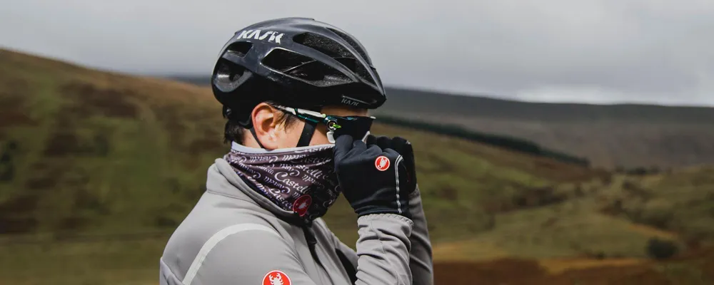 Road rider pulling up a neck tube wearing castelli