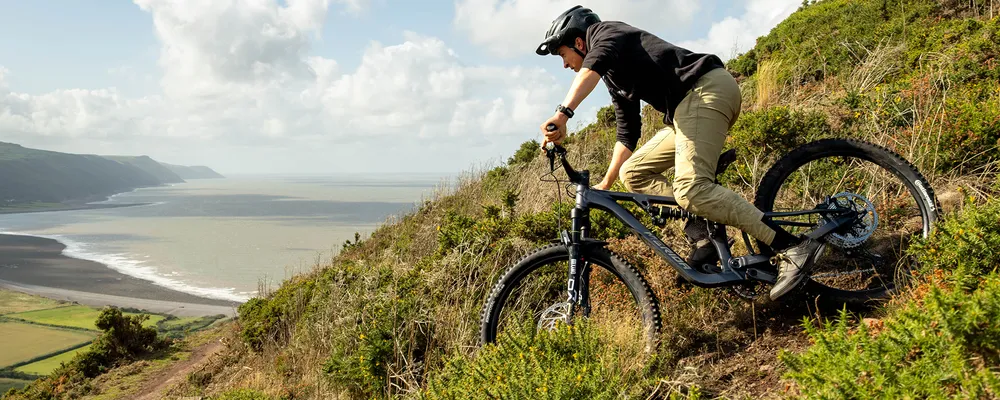 riding a mountain bike down a hill near the coast in devon