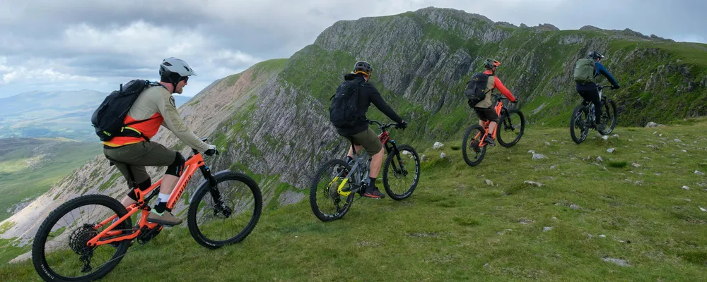 4 mtb riders in the mountain with backpacks