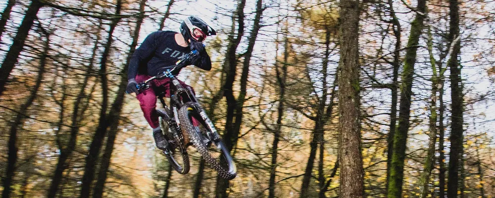 mountain biker rider jumping wearing goggles with full face helmet