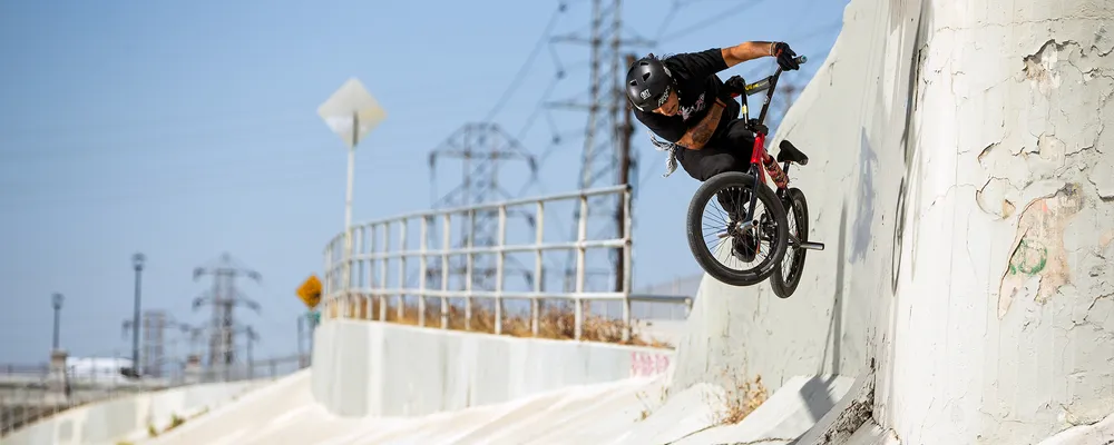 A BMX bike rider jumps off of a wall ride