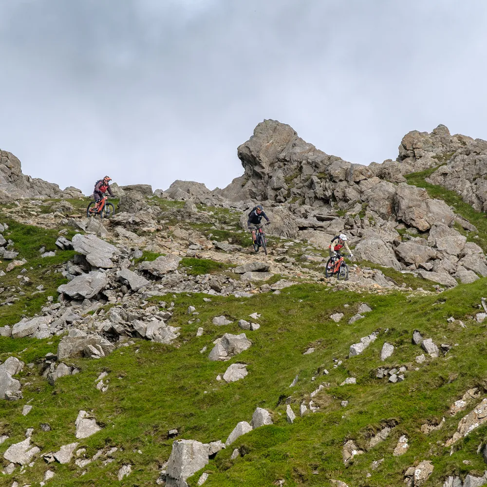 Three mountain bikers descending from peak of Cadair Idris in Wales