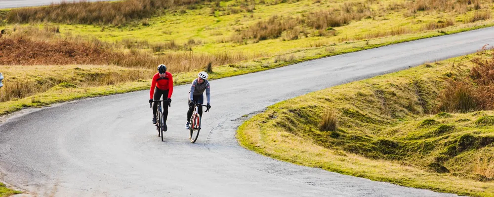 Two road riders cornering on a mountain ride