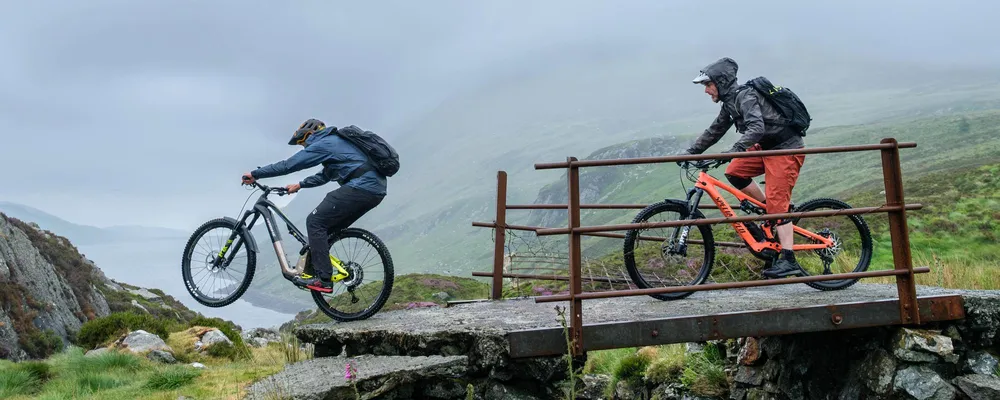 two mountain bikers riding on a wet day in the hills with waterproof jackets