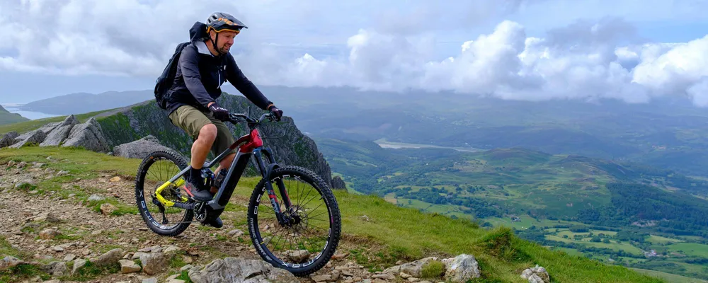 Mountain biker on an e-bike riding along a mountain ridge