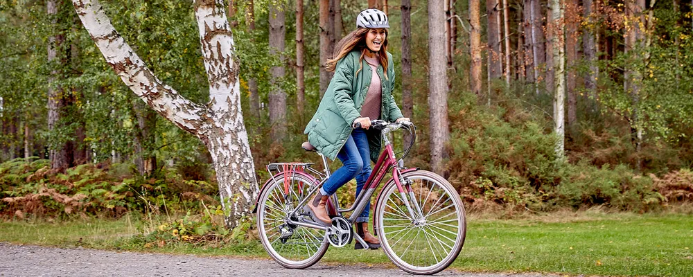 Woman riding a hybrid classic bike in the park