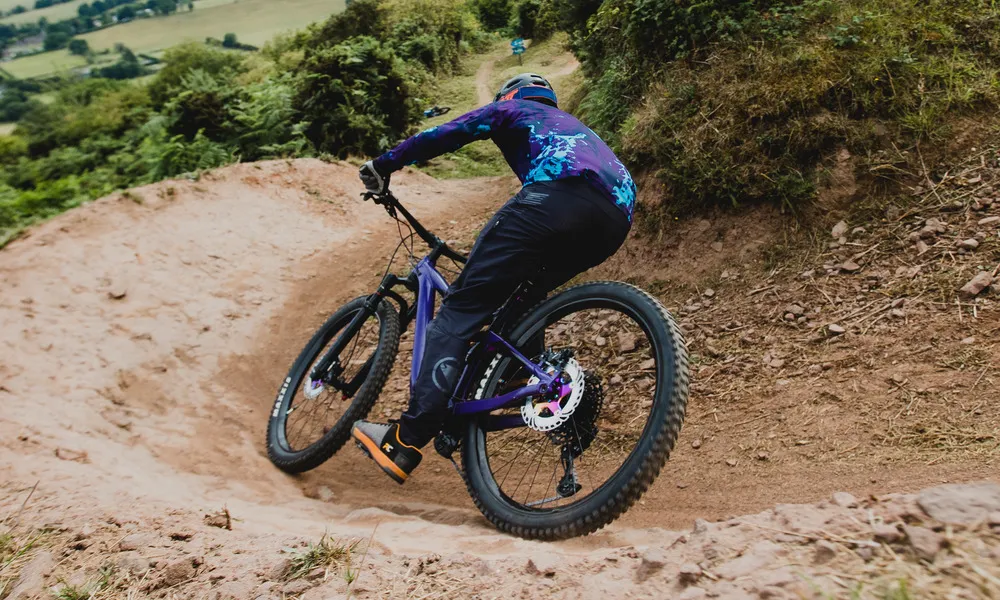 MTB rider cornering in dirt farm