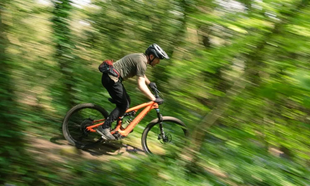 Pan shot, riding the specialized Levo SL in the woods on a sunny day