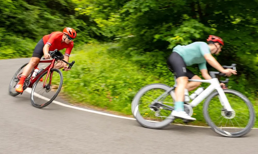 Tow road cyclists descending round a corner